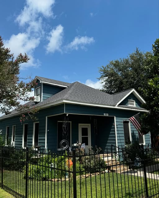 Classic bungalow repainted in deep blue-green with crisp white trim