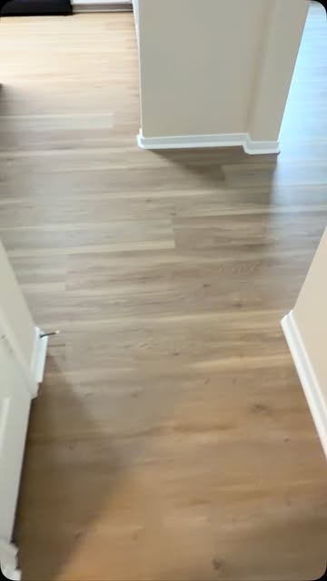 Light oak luxury vinyl plank flooring installed through a bedroom and hallway
