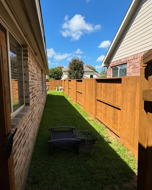 Side yard fence fully stained in warm cedar tone