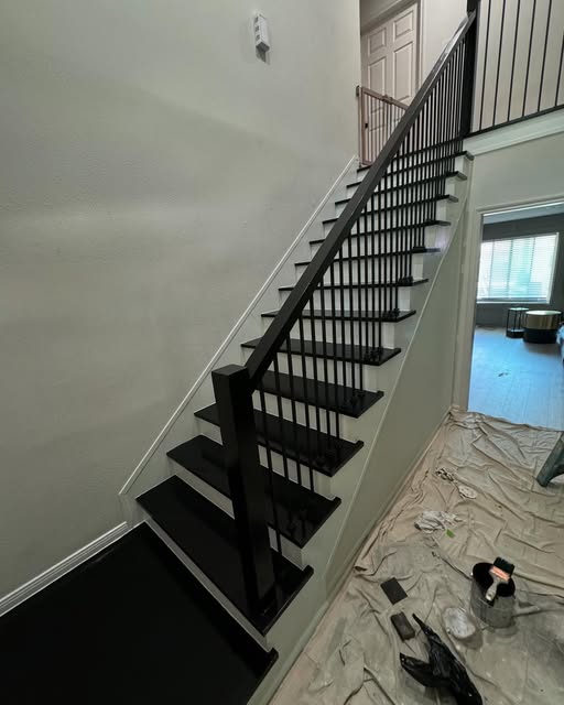 Staircase refinished with black treads, railing and balusters against white risers