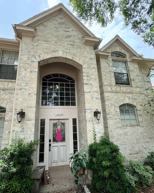 Stone-and-brick two-story entryway with refreshed white door and trim