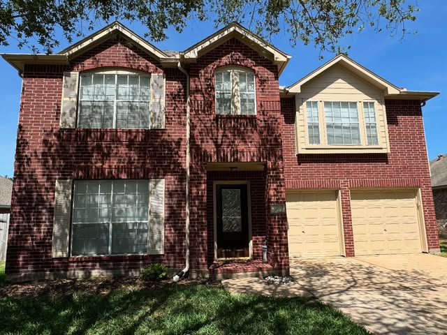 Two-story brick home with repainted siding, trim and garage doors